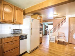 eine Küche mit weißem Kühlschrank und Holzschränken in der Unterkunft Boho Waterfront Getaway 5 Bedroom Retreat in Solomons