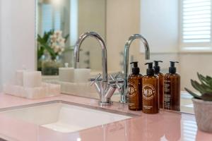 a bathroom counter with two bottles of soap and a sink at Buckingham & Lloyds in London +109 photos