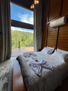 a bed in a room with a large window at Sítio Rancho Mineiro in Domingos Martins