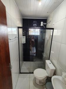 a small bathroom with a toilet and a shower at Casa Praia in Piçarras