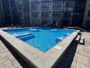 a swimming pool with blue water in front of a building at Fraser Crossing Top floor 3603 in Winter Park