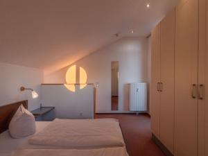 a bedroom with a white bed and a light on the wall at elegant eingerichtete Ferienwohnung in Granzow