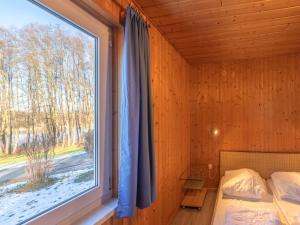 Un dormitorio con una cama y una ventana grande. en Ferienhaus im skandinavischen Stil, en Granzow