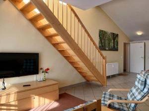 a living room with a staircase with a couch and a tv at elegant eingerichtete Ferienwohnung in Granzow