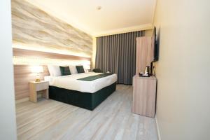 a hotel room with a bed and a television at Rose Holiday i3 روز هوليداي in Al Madinah