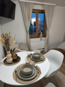 ein weißer Esstisch mit Tellern darauf in der Unterkunft Apartment Panorama in Eischoll + 18 Fotos