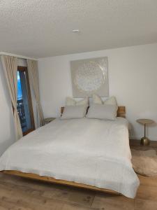 ein Schlafzimmer mit einem großen Bett mit weißen Laken und Kissen in der Unterkunft Apartment Panorama in Eischoll