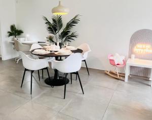 翁纳LilaMoon的一间有黑色桌子和白色椅子的餐厅