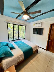 Un dormitorio con una cama y un ventilador de techo. en Cristo rey hostal campestre, en Cali