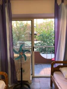 a room with a fan in front of a window at ROYAL Hostel in Tirana