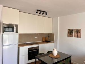 a kitchen with white cabinets and a table with a vase on it at Anahata Homes in Antigua
