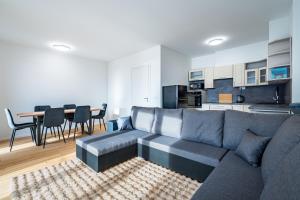 un salon avec un canapé gris et une cuisine dans l'établissement Baker Balcony Apartment, à Brno
