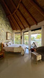 サンタ・カタリナにあるCabañas Time Outの石壁のベッドルーム1室(大型ベッド1台付)