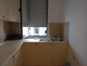 a kitchen with a sink and a window at ROYAL Hostel in Tirana