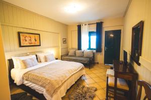 a bedroom with a bed and a couch at Aphrodite's Inn Kalavrita in Kalavrita