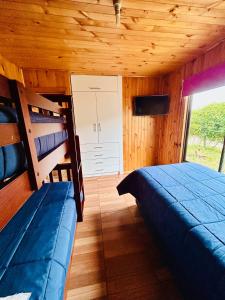 ein Schlafzimmer mit zwei Etagenbetten in einer Kabine in der Unterkunft Cabaña en chovellen in Pelluhue