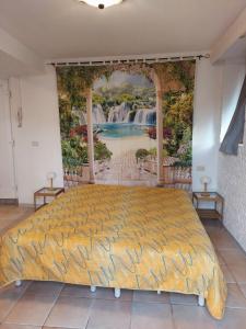 a bedroom with a large bed with a painting on the wall at Villetta Rosa in Lavena Ponte Tresa