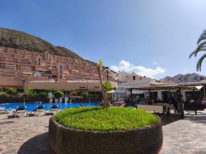 a resort with a pool and chairs and a building at Dreams Castle in Los Cristianos