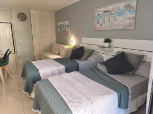 a bedroom with three beds and a couch at Dreams Castle in Los Cristianos
