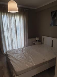 a bedroom with a white bed with a window at MCD Apartment Central in Craiova