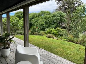 马塔卡纳Garden Apartment的花园门廊上摆放着一把白色椅子