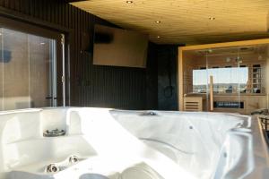 a white bath tub in a room with a kitchen at Black barn in Rusinowo +74 photos