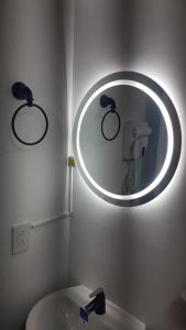 espejo en el baño con aseo y lavabo en Apartaestudio Armenia quindio, en Armenia