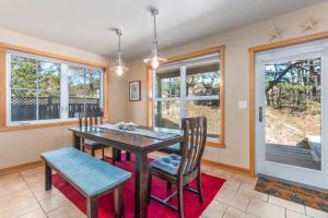 een eetkamer met een tafel, stoelen en ramen bij Starfish in Pacific City