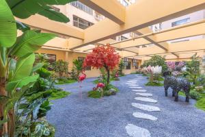 ein Gehweg in der Mitte eines Gebäudes mit Pflanzen in der Unterkunft Qiuguo Garden Hotel in Dongguan