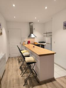 a kitchen with a counter and two bar stools at Studio rénové avec balcon & vue sur les montagnes in Saint-Clément sur Durance +6 photos