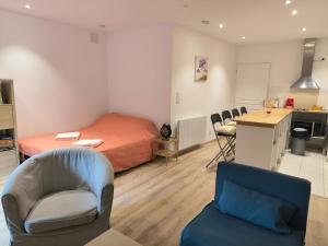 a bedroom with a bed and a kitchen with chairs at Studio rénové avec balcon & vue sur les montagnes in Saint-Clément sur Durance
