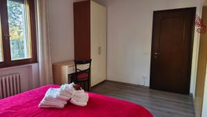 ein Schlafzimmer mit weißen Handtüchern auf einem rosa Bett in der Unterkunft Casa Kendra in Montegrotto Terme + 19 Fotos