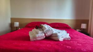 eine Person liegt auf einem rosa Bett in der Unterkunft Casa Kendra in Montegrotto Terme