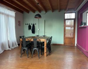 a dining room with a wooden table and black chairs at Casa Sol de Enero in Malargüe +18 photos