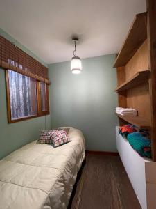 a small bedroom with a bed and a window at Casa Sol de Enero in Malargüe +18 photos