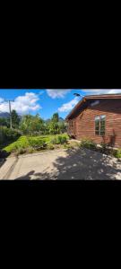 ein Backsteinhaus mit einer Auffahrt neben einem Gebäude in der Unterkunft Cabaña pasaje las rosas in Pucón