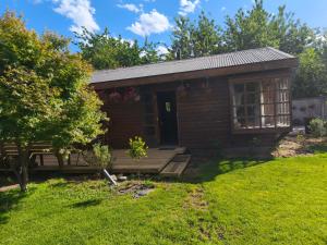eine kleine Holzhütte mit Veranda und Garten in der Unterkunft Cabaña pasaje las rosas in Pucón