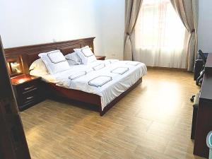 una camera da letto con un letto grande con lenzuola e cuscini bianchi di 1 Bedroom Bungalow in Alalubosa GRA a Ibadan