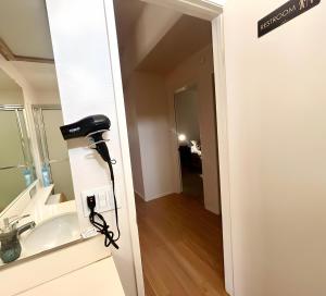 bagno con lavandino e asciugacapelli. di Starlight Western Room a Hemet