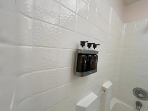 un bagno piastrellato bianco con un distributore di sapone nero di Starlight Western Room a Hemet