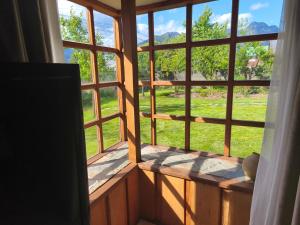 a window with a view of a field of grass at Cabaña pasaje las rosas in Pucón +1 photo