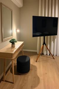 ein Wohnzimmer mit einem TV, einem Tisch und einem Stuhl in der Unterkunft BE ONE HOTEL Caldas da Rainha - by MHMB Hospitality in Caldas da Rainha