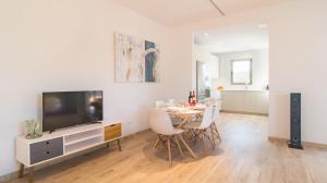 a living room with a dining table and a tv at Can Colomer Ferragut in Artá