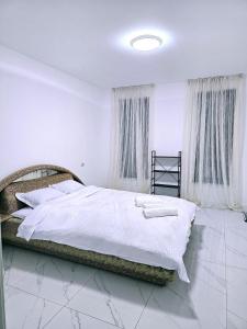 a bedroom with a large bed with white sheets at Casa in Şimnicu de Jos