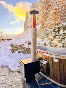 Una pequeña estufa está en una terraza en la nieve. en Le Raidillon Verbier, en Verbier