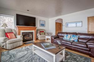 un soggiorno con divano in pelle e camino di Oceans Song a Lincoln City