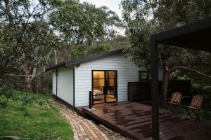 a house in the woods with a deck at Treetop Retreat with Private Spa Mountain Views in Warburton