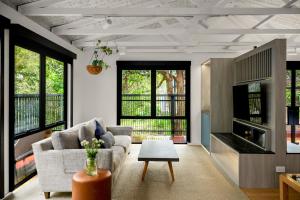 a living room with a couch and a table at Treetop Retreat with Private Spa Mountain Views in Warburton