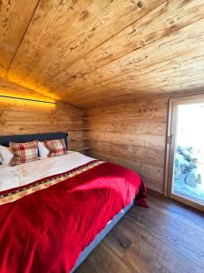 una cama en una habitación con una pared de madera en Le Raidillon Verbier, en Verbier