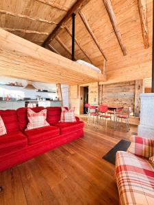 Una sala de estar con un sofá rojo y una mesa. en Le Raidillon Verbier, en Verbier